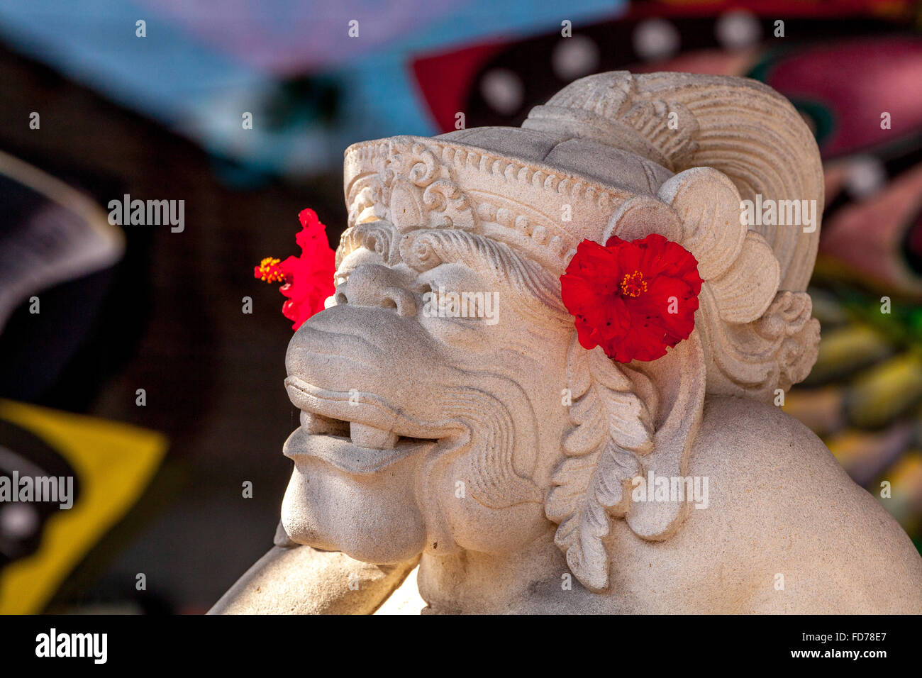 Affengott Hanuman aus Stein mit roten Hibiskus Blumen, weißer Kalkstein, Hanuman, Hinduismus geschnitzt, hinduistische,,, Straße Szene, Ubud, Stockfoto