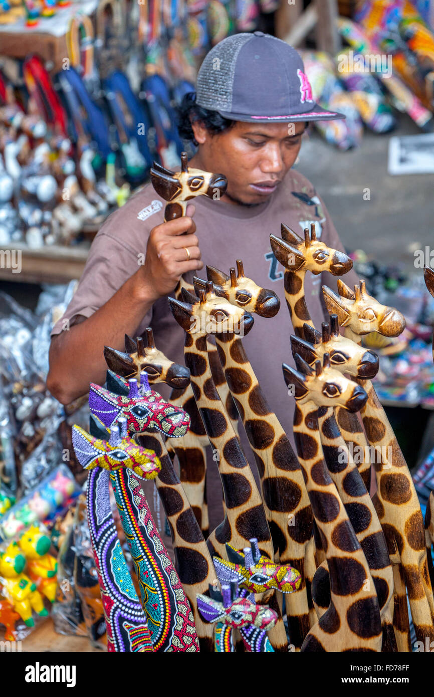 Markt-Händler, Händler auf einem Basar in Ubud mit Holz Giraffen, Ubud, Bali, Indonesien, Asien Stockfoto