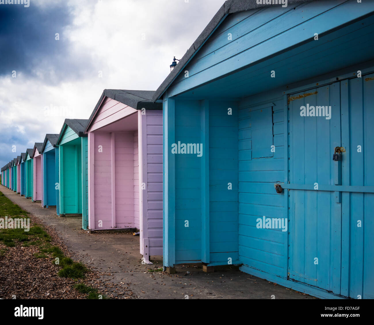 Strandhütten in Southsea, Portsmouth, England. Gesperrt für den Winter mit dunklen Regenwolken am Himmel oben Stockfoto