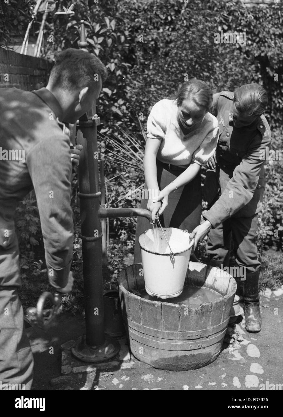 Soldaten der Wehrmacht Hilfe eines Mädchens, 1935 Stockfoto