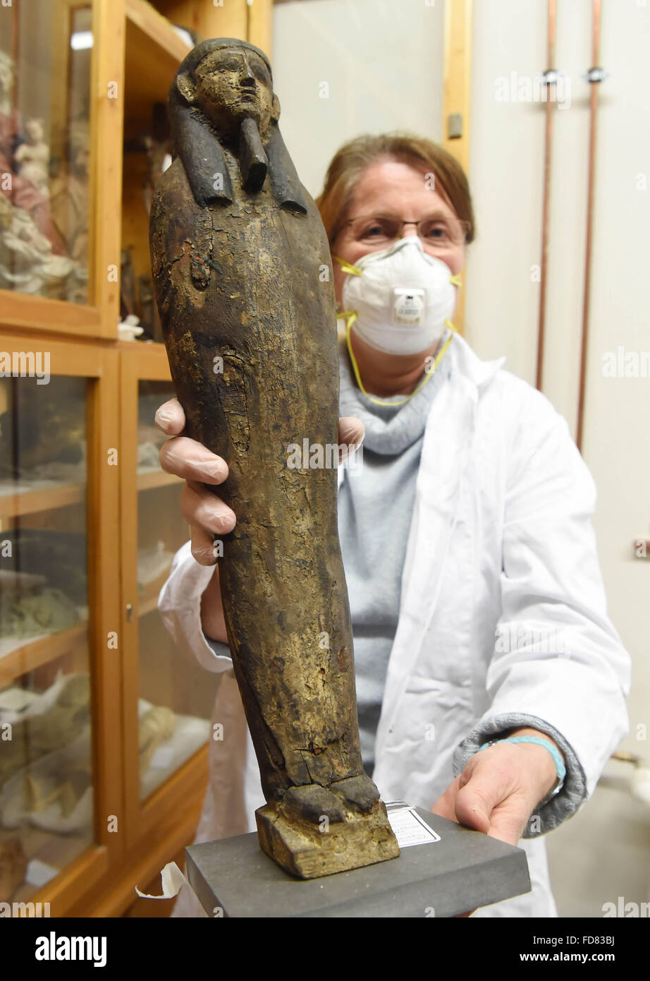 Karlsruhe, Deutschland. 28. Januar 2016. Andrea Wähli, Restaurator für Gemälde und Skulptur, Olding Ptah-Sokar-Osiris-Skulptur aus der griechisch-römischen Zeit zwischen dem 1. Jahrhundert v. Chr. und dem 1. Jahrhundert n. Chr., in einem Lagerraum im Badisches Landesmuseum in Karlsruhe, Deutschland, 28. Januar 2016. Das Museum will verwandeln sich in eine Art Benutzerarchiv auf ihren 100. Geburtstag in 3 Jahren. Foto: ULI DECK/DPA/Alamy Live-Nachrichten Stockfoto