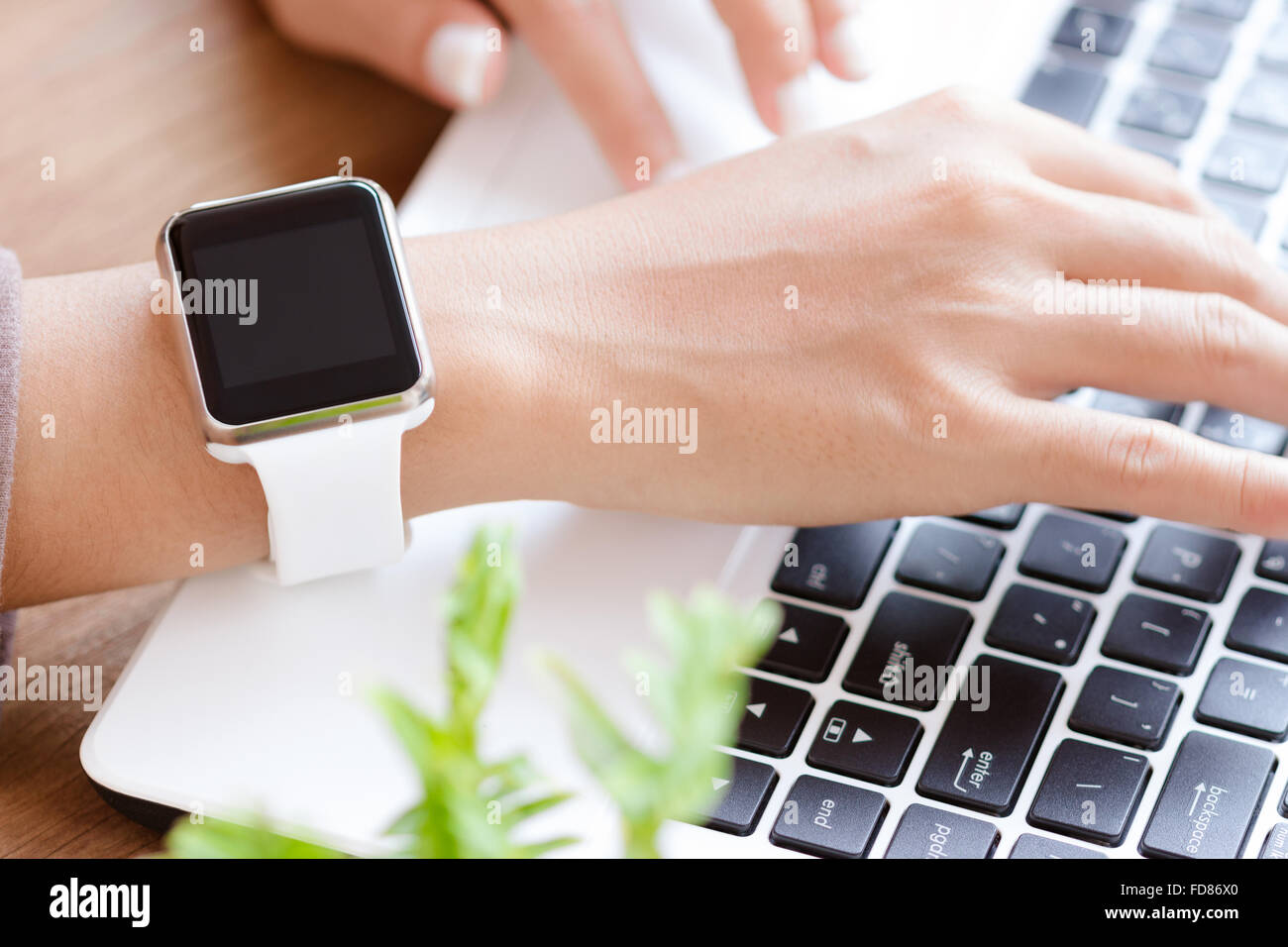 Closeup Hand Uhr mit Laptop am Schreibtisch Stockfoto