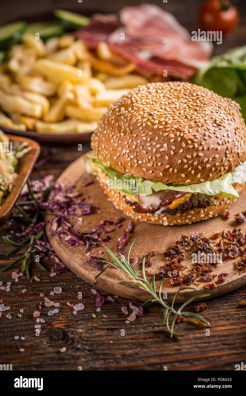 Beef-Burger im Brötchen mit getrockneten Zwiebeln und Salat Stockfoto