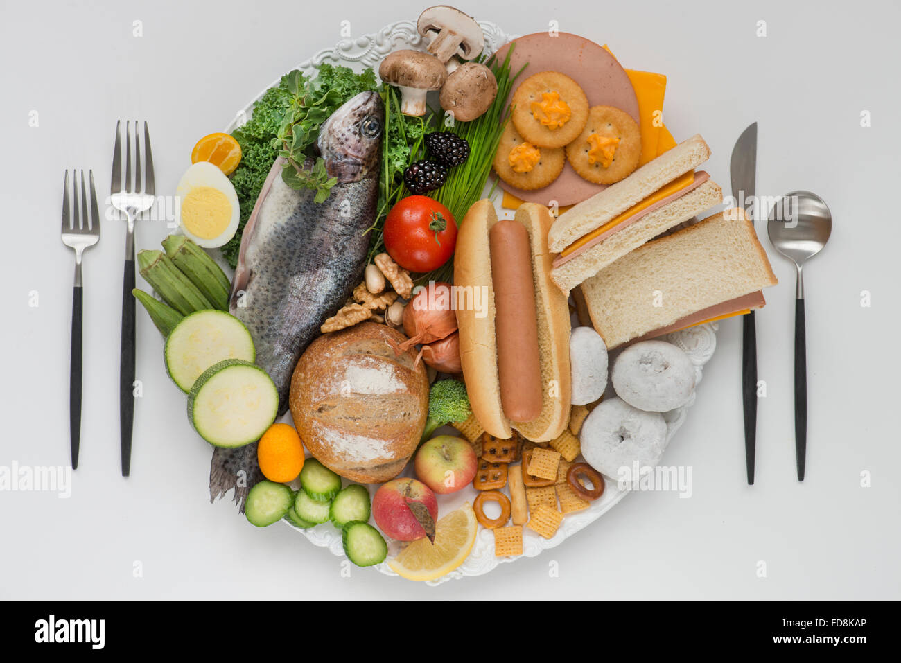 Teller mit halben gesunde Ernährung, die Hälfte der Platte mit verarbeiteten ungesund essen. Stockfoto
