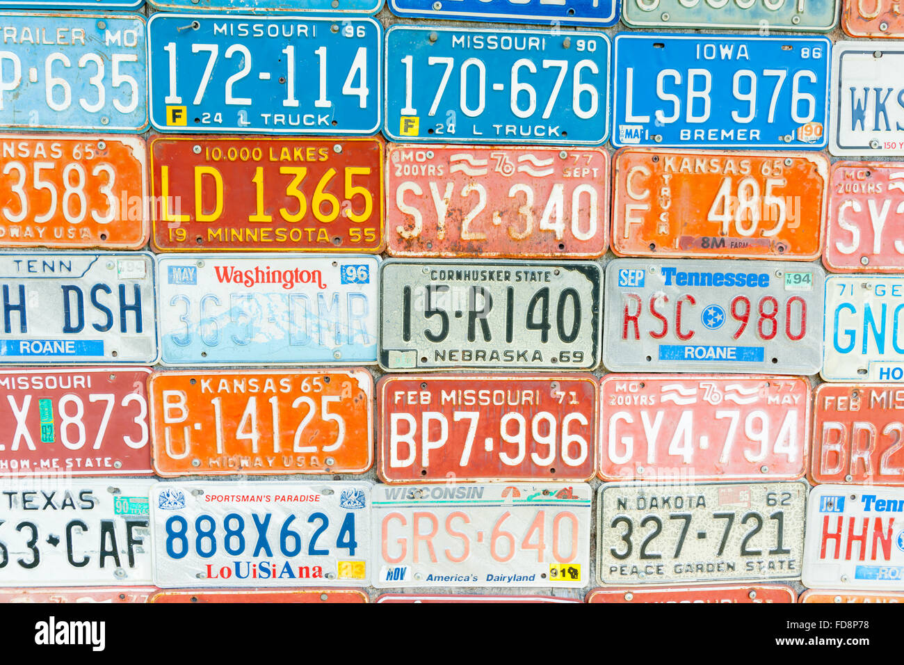 Alten veraltet Kfz-Kennzeichen an der Wand zeigen Palette von Farben,  Staaten, Zahlen und Nick Statusnamen montiert Stockfotografie - Alamy
