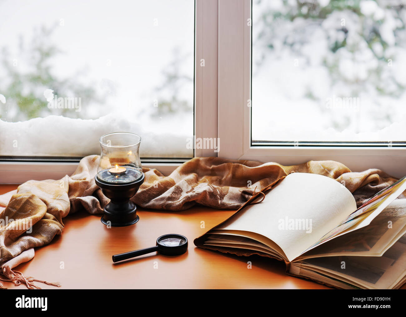 Öffnen, Fotoalbum, Kerze, Lupe und und Beige warmen Plaid befindet sich auf einer stilisierten hölzerne Fensterbank. Winter-Konzept von c Stockfoto Öffnen, Fotoalbum, Kerze, Lupe und und Beige warmen Plaid befindet sich auf einer stilisierten hölzerne Fensterbank. Winter-Konzept von c Stockfoto