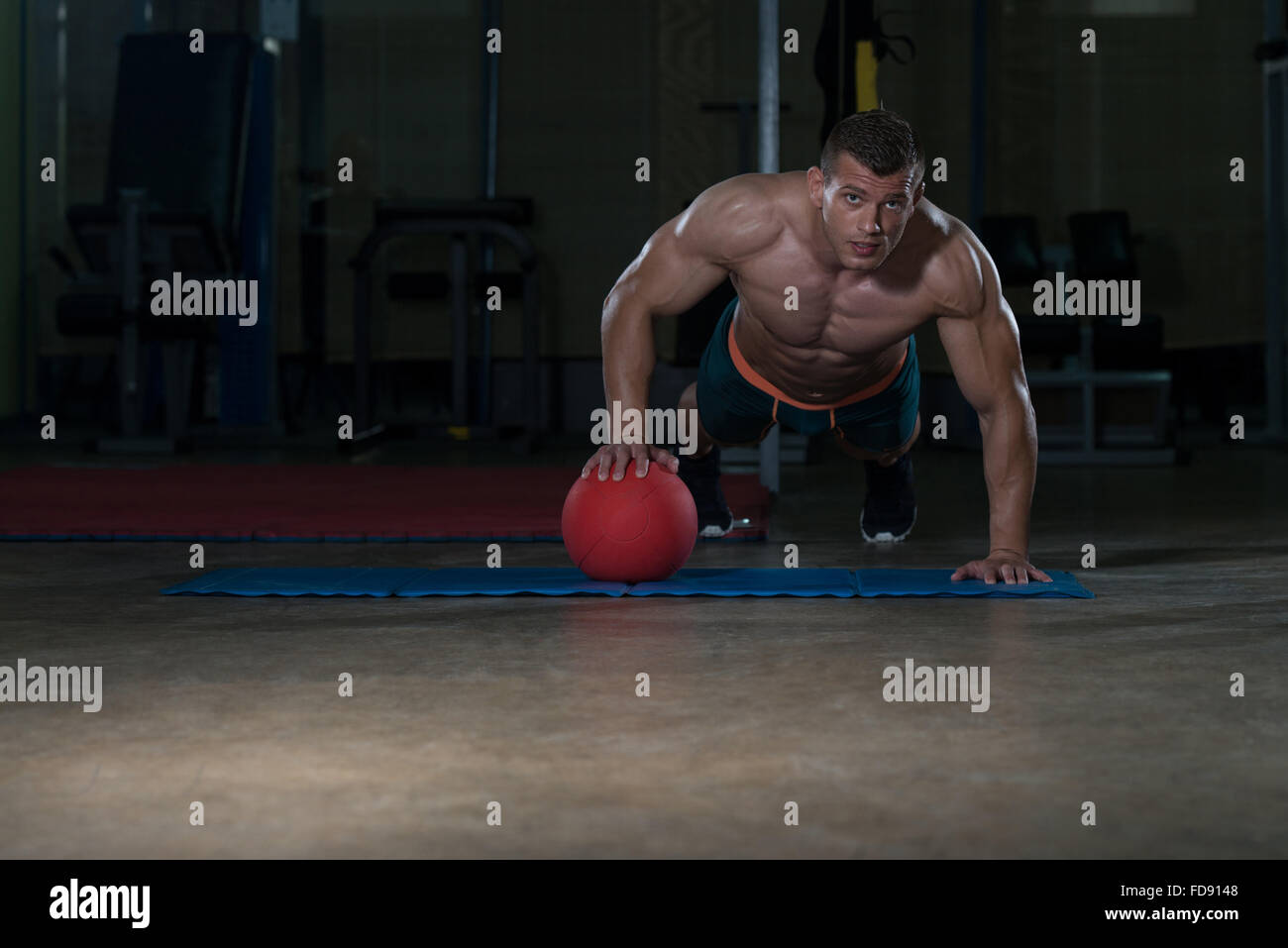 Junge Erwachsene Sportler tun drücken Ups Medizinball im Rahmen von Bodybuilding-Training Stockfoto