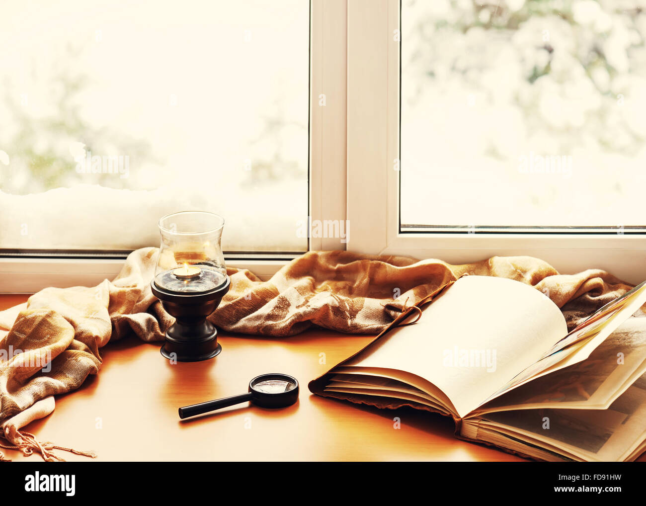 Öffnen, Fotoalbum, Kerze, Lupe und und Beige warmen Plaid befindet sich auf einer stilisierten hölzerne Fensterbank. Winter-Konzept von c Stockfoto Öffnen, Fotoalbum, Kerze, Lupe und und Beige warmen Plaid befindet sich auf einer stilisierten hölzerne Fensterbank. Winter-Konzept von c Stockfoto
