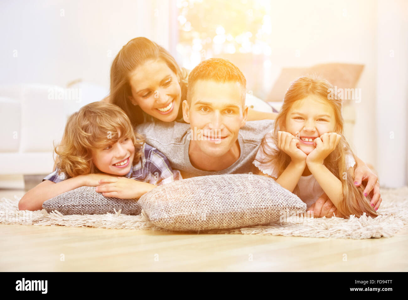 Glückliche Familie mit zwei Kinder Lächeln zu Hause im Wohnzimmer Stockfoto