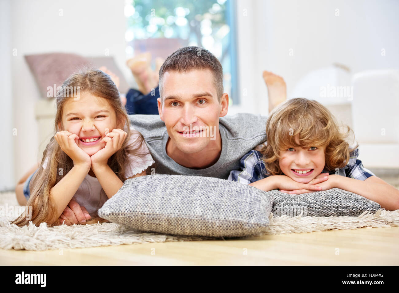 Glücklicher Vater und Kinder im Wohnzimmer zu Hause Stockfoto