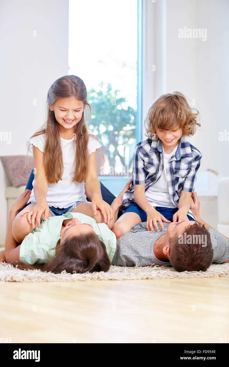 Glückliche Familie mit zwei Kindern herumtollen zu Hause im Wohnzimmer Stockfoto