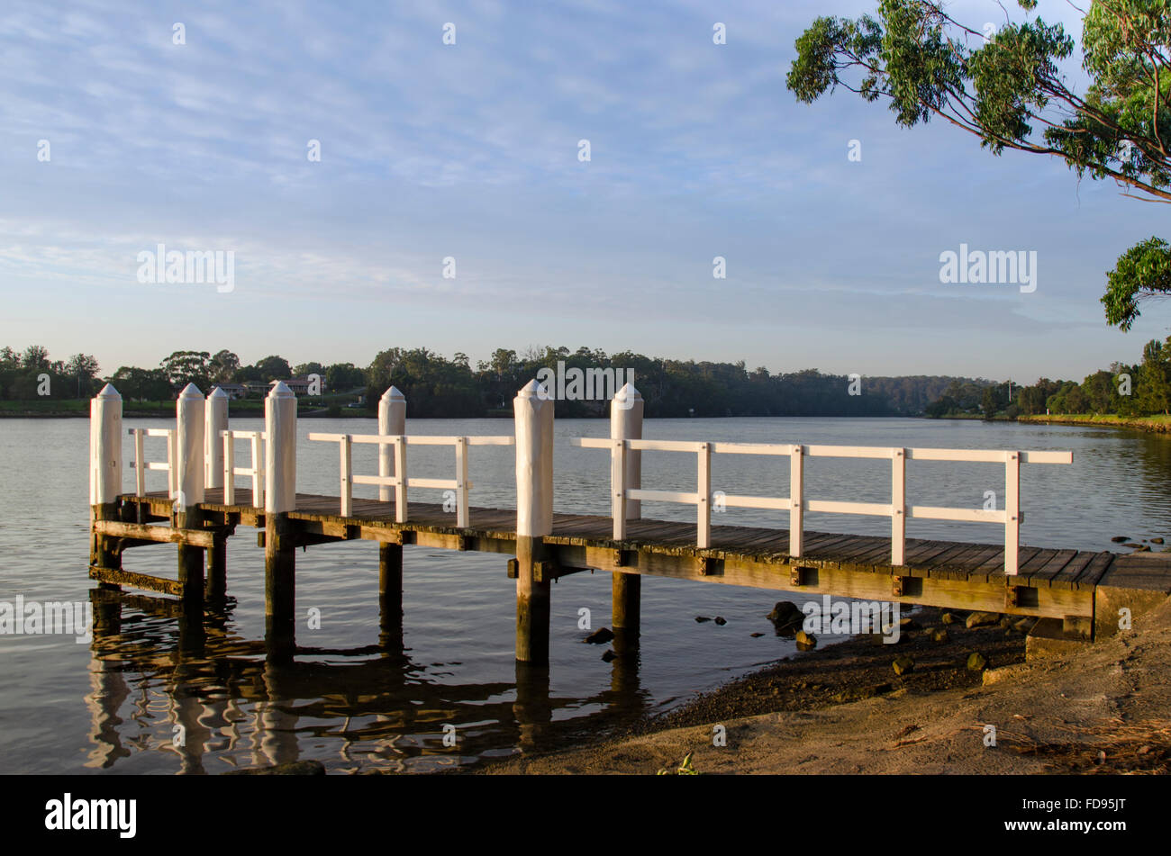 Ein Kai oder Steg ragt in den goldenen Strahlen des Tagesanbruchs in den Shoalhaven River in der Nähe von Nowra in New South Wales, Australien, hinein Stockfoto