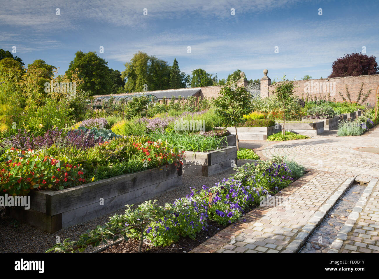 Ein seichtes Bächlein Wasserspiel und angehobenen Betten. Die Küche Garten im Rudding Park, North Yorkshire, UK. Sommer, Juli 2015. Stockfoto