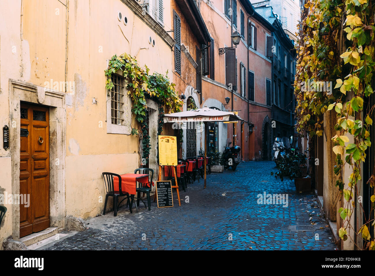 Eine typische Straße und rustikalen Restaurant mit Sitzmöglichkeit im Freien in Rom, Italien Stockfoto