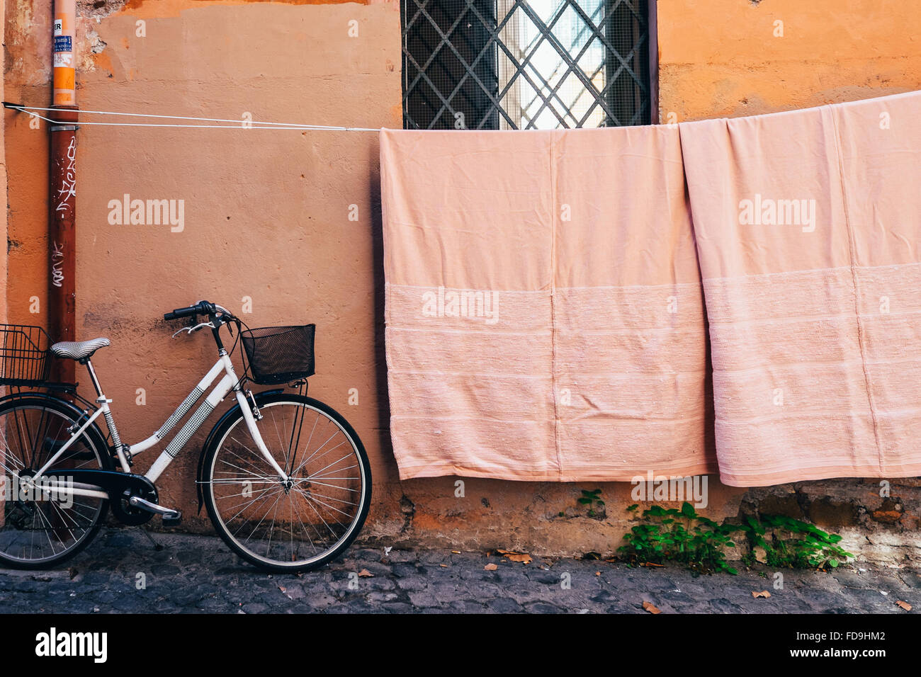 Farblich abgestimmte Wäsche aufgehängt, um zu trocknen und eine geparkte Fahrrad in Trastevere Neighboudhood von Rom, Italien Stockfoto