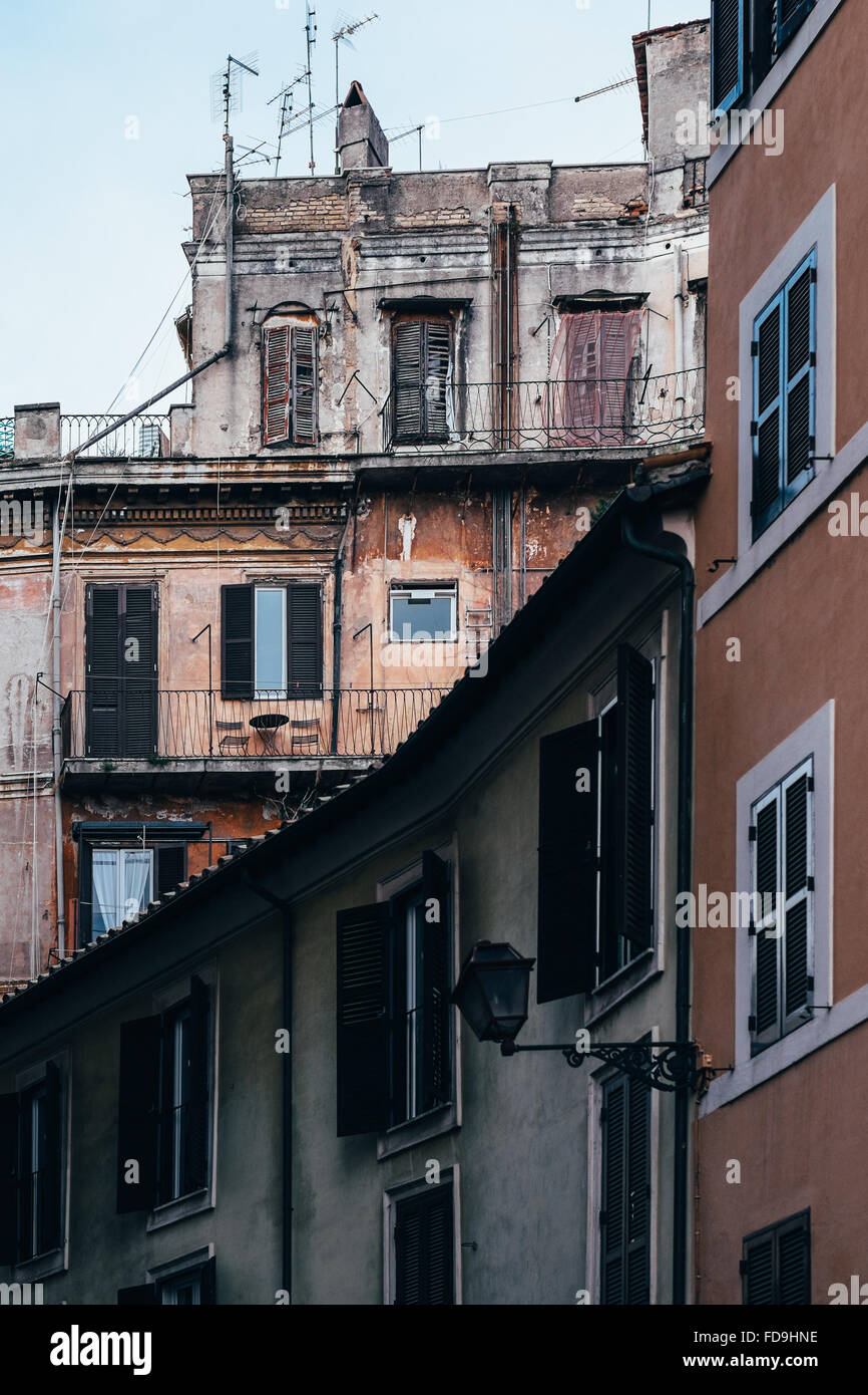 Geschichtete Gebäude mit Fensterläden Zeit getragen und grobe Stuckwänden in Rom, Italien. Stockfoto