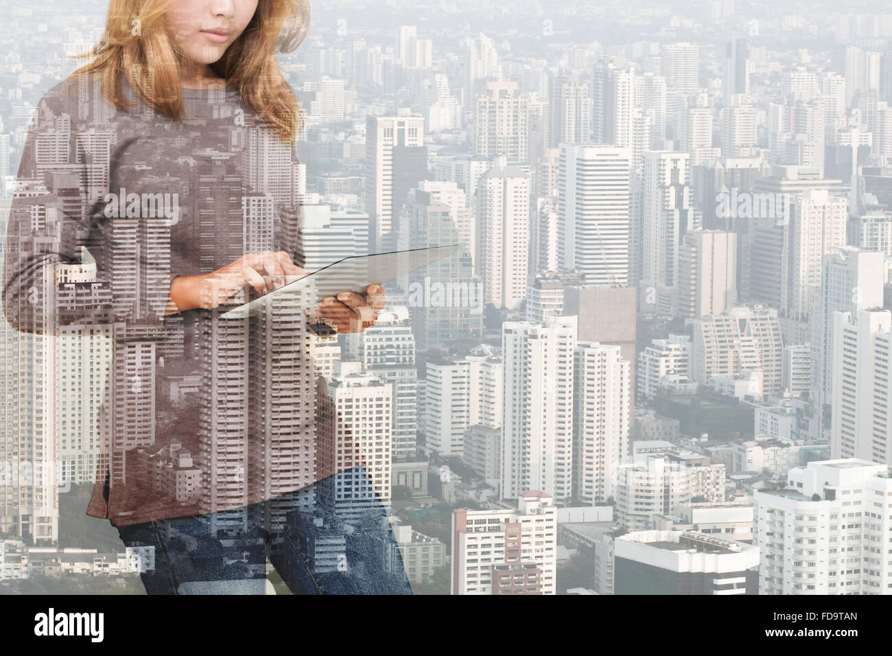 Doppelbelichtung Frau mit Tablet-Technologie und Städtebau-Hintergrund Stockfoto