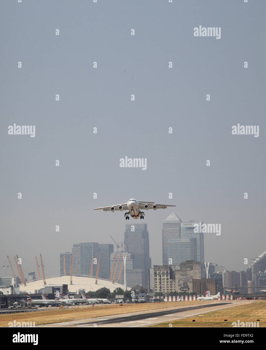 Ein British Aerospace 146 Jet hebt ab Flughafen London City. Canary Wharf und die O2-Arena zeigt im Hintergrund. Stockfoto