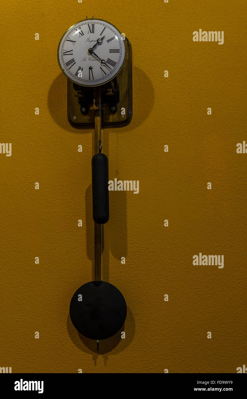Eine alte Uhr auf eine gelbe Wand Stockfoto