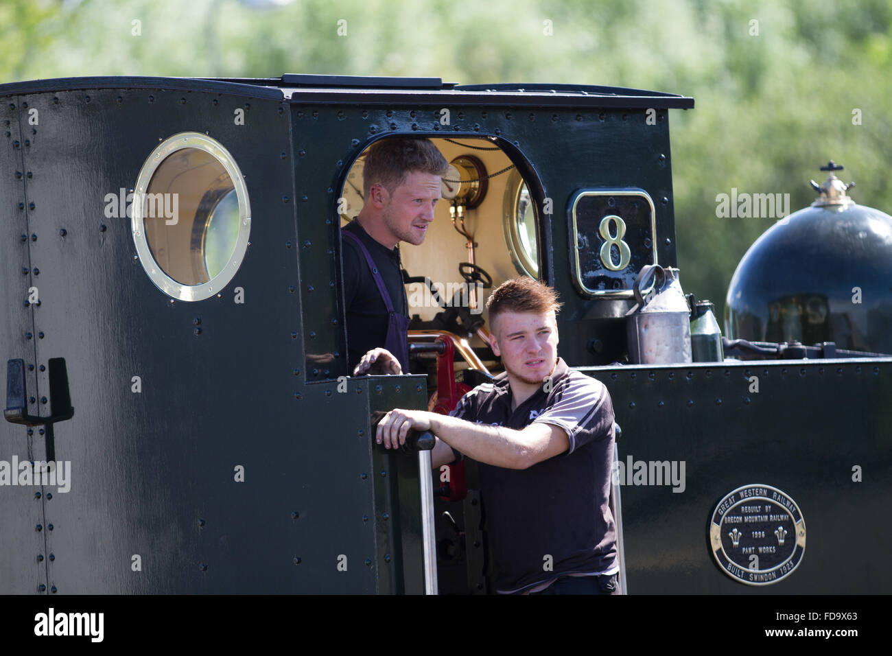 Der junge Fahrer und Feuerwehrmann posieren auf ihre Lokomotive auf Vale des Rheidol Railway Nr. 8 in Aberystwyth Station. Stockfoto