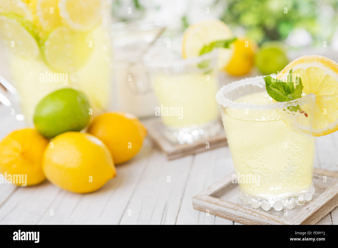 Erfrischende hausgemachte Limonade auf einem rustikalen Gartentisch in helles Licht. Stockfoto