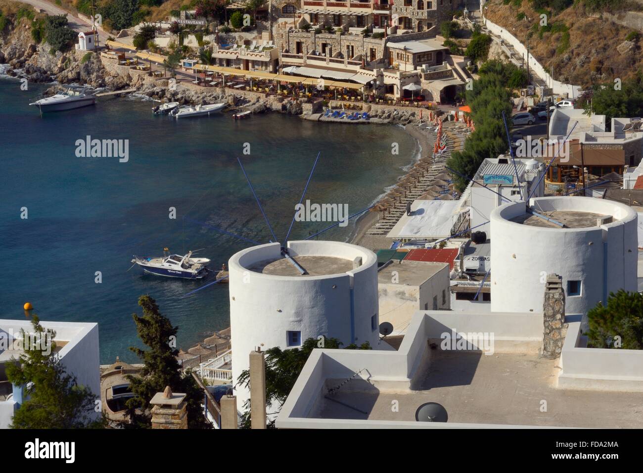 Alte Windmühlen, als Ferienunterkunft über Panteli Dorf und Strand, Leros, Dodekanes, Griechenland wiederhergestellt. Stockfoto