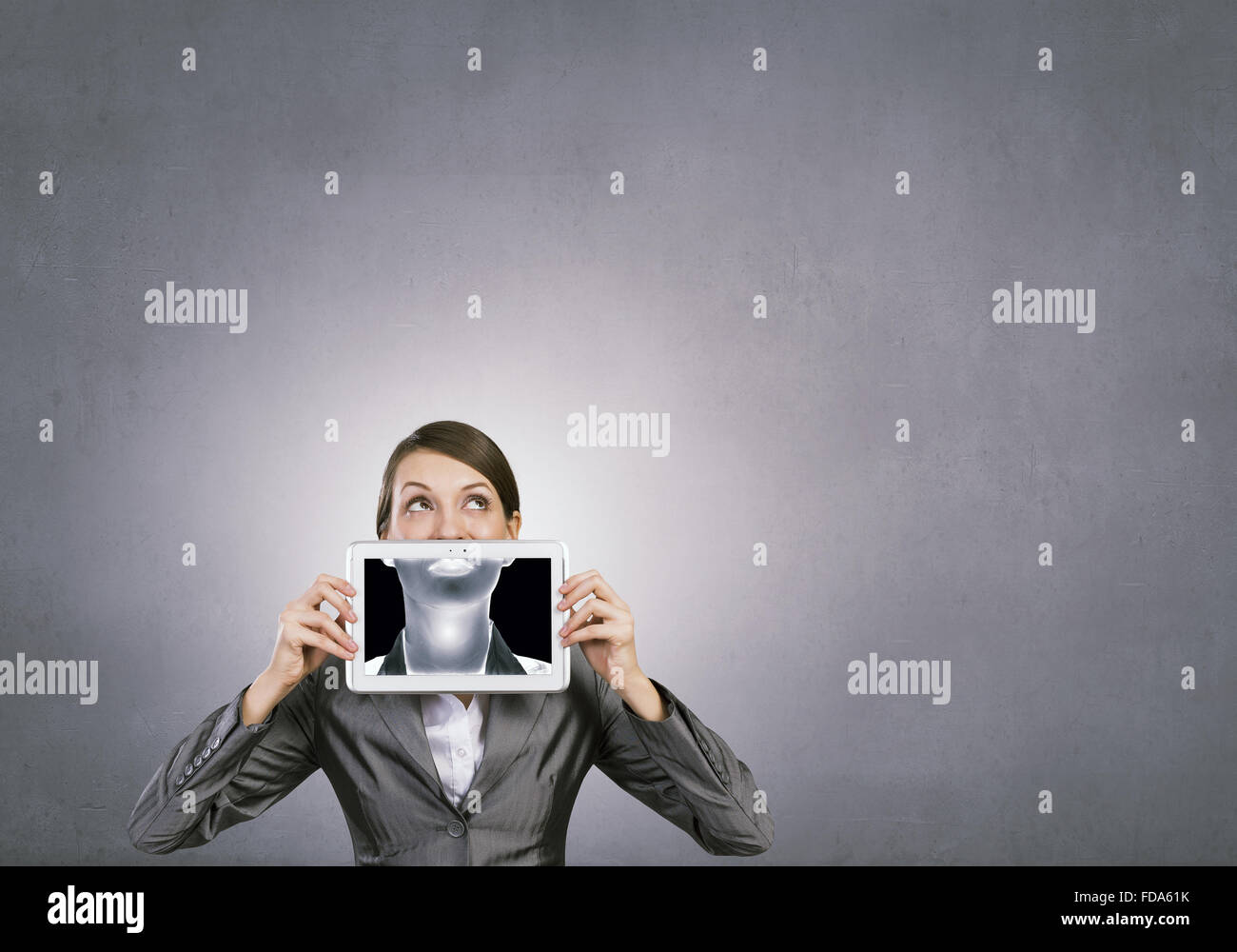 Schöne junge Frau, die TabletPC an den Mund halten Stockfoto