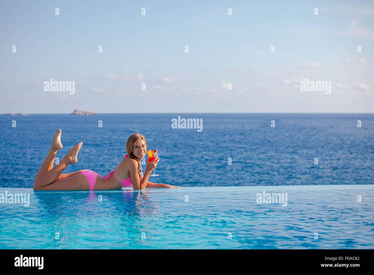 Sommer-Frau trinken cocktail auf Mallorca im Infinity-pool Stockfoto