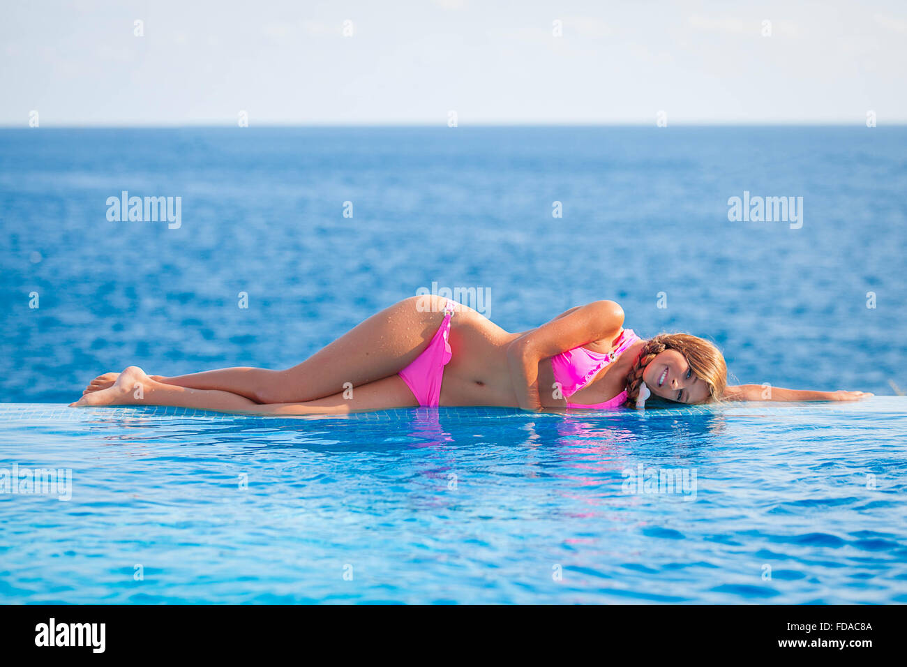 Sommer-Frau Sonnenbaden im Infinity-Pool in Mallorca oder Mallorca Stockfoto