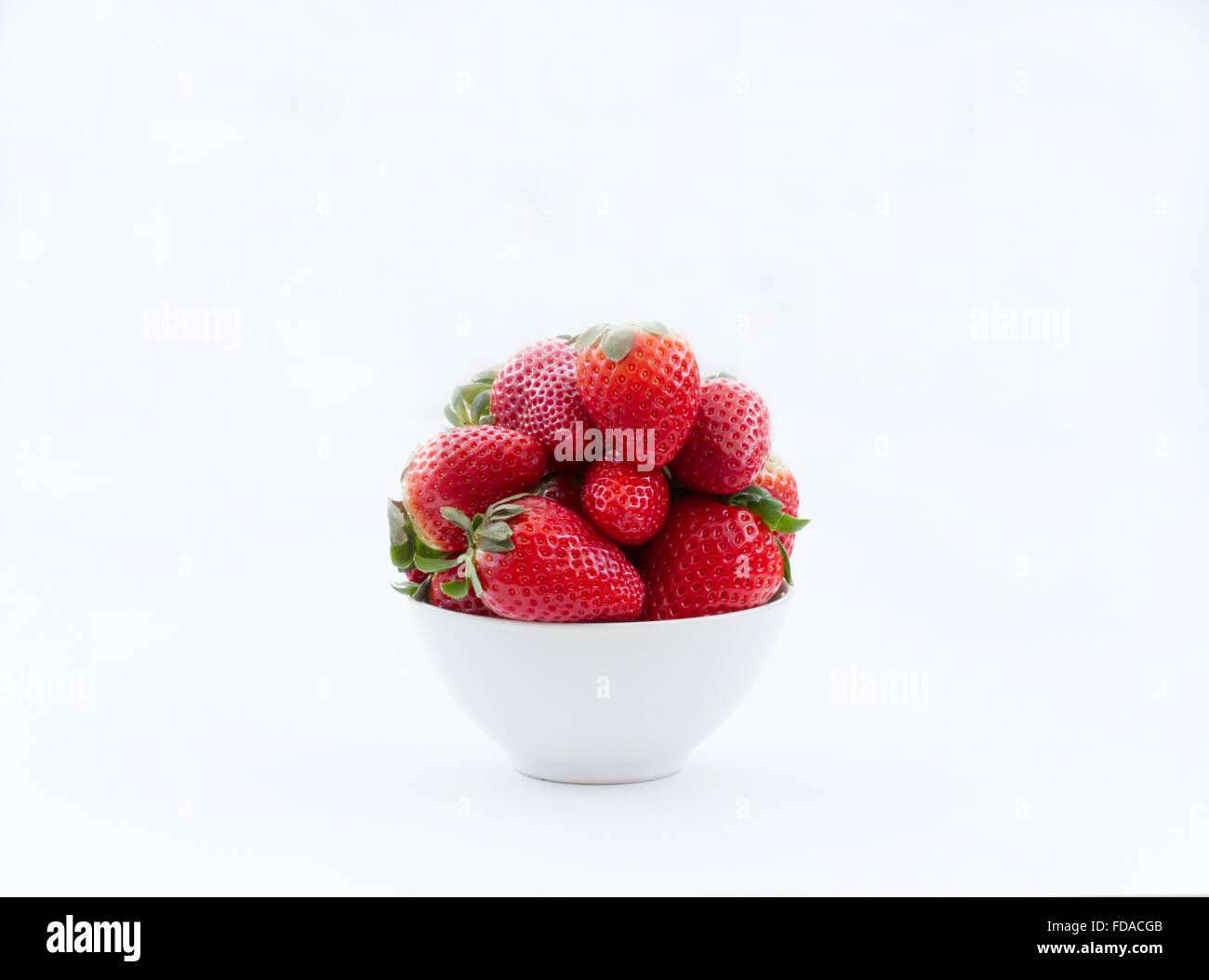 Eine Schüssel voll mit frischen Erdbeeren auf einem isolierten weißen Hintergrund. Querformat. Stockfoto
