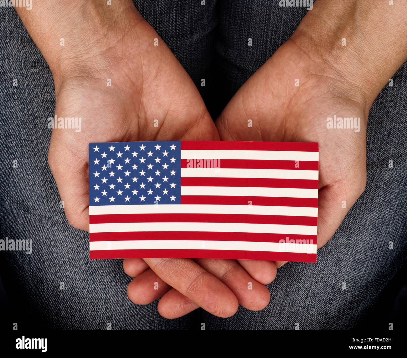 Frau, die amerikanische Flagge auf ihre Handflächen. Patriotismus und Freiheit Konzept. Stockfoto