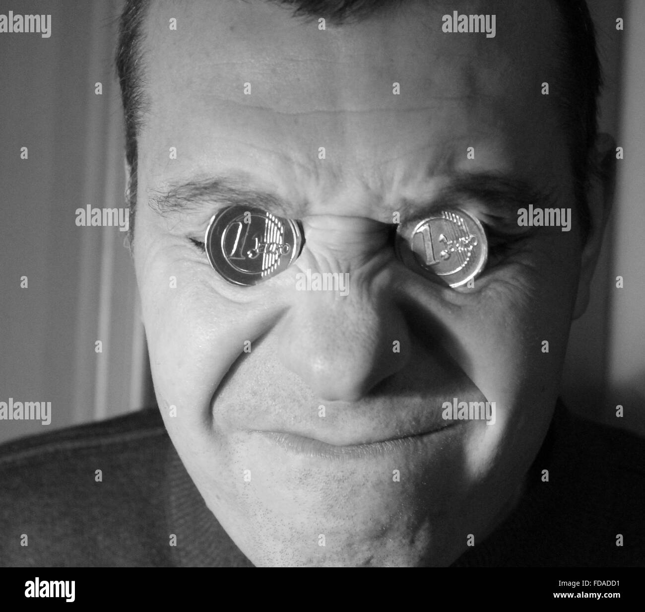 junger Mann mit zwei Münzen der Glanz auf den Augen-Buchsen mit Grimasse  des Schmerzes auf dem Gesicht Loser in Krisenzeiten Stockfotografie - Alamy