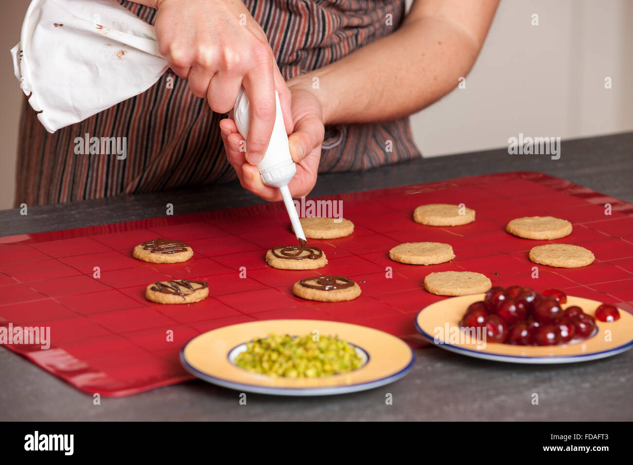 Frau, die Cookies mit Schokolade verzieren Stockfoto