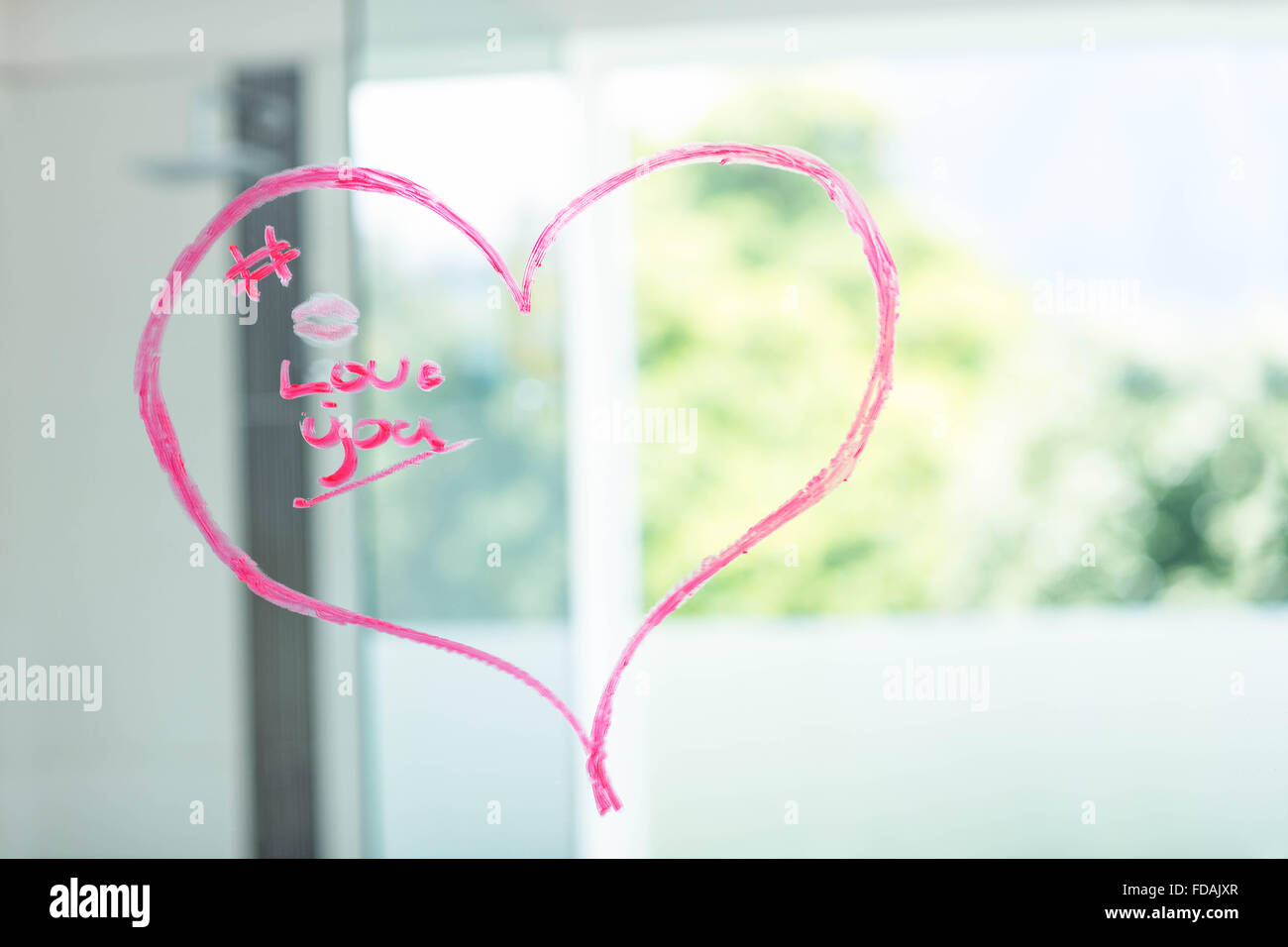 Herz auf einem Spiegel mit rosa Lippenstift geschrieben Stockfoto