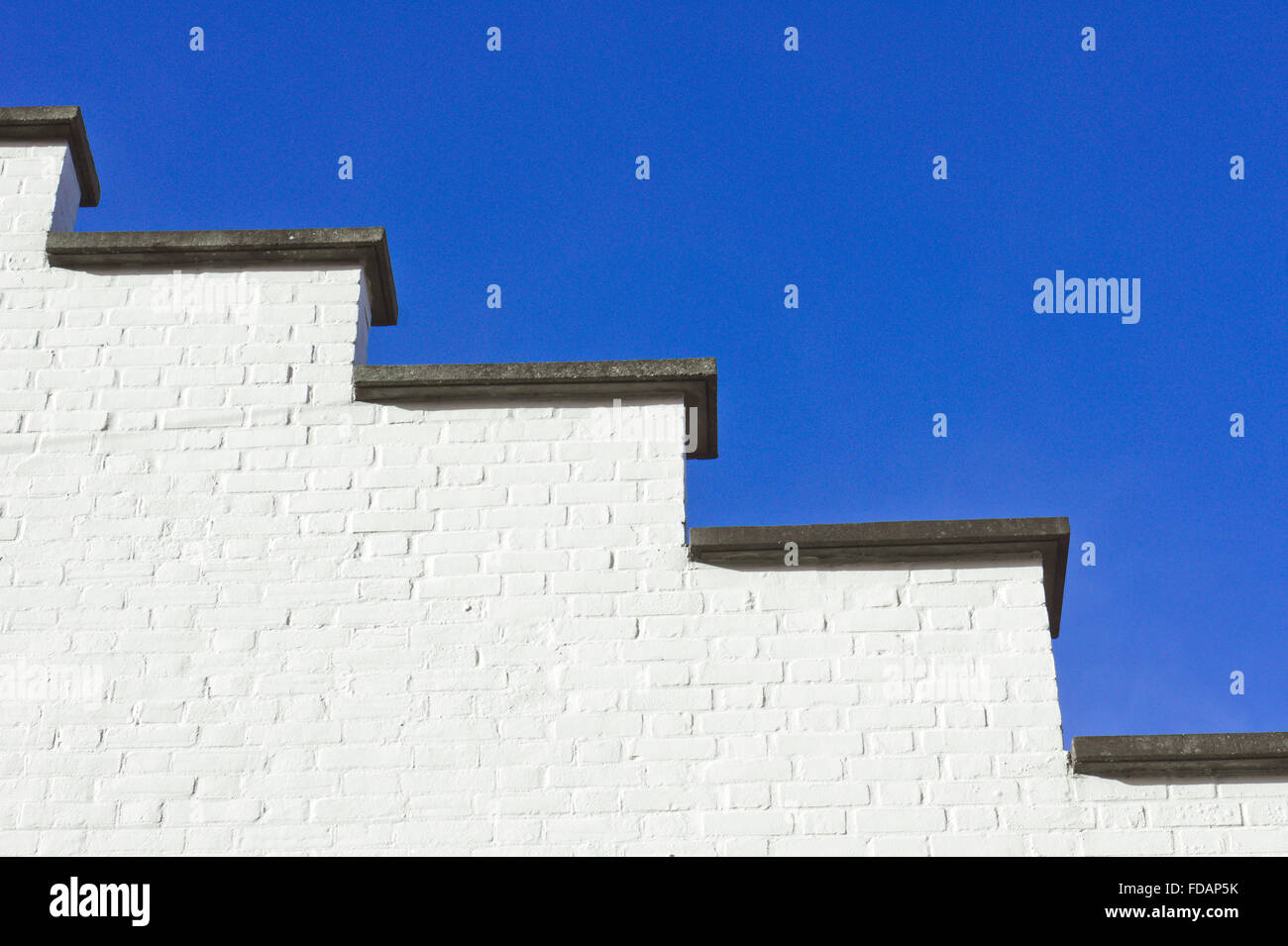 Bestandteil einer weißen Wand auf einem 1930er Jahre Art Deco Gebäude vor blauem Himmel Stockfoto