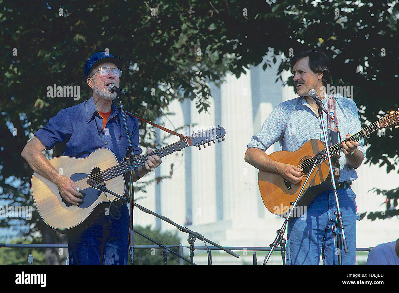 Washington, DC, USA, 4. August 1985 Tom Chapin und Pete Seeger spielen Gitarren während der Frieden Band Protest auf der Mall in Washington DC. Chapin ist ein Grammy Award-Winning amerikanischer Musiker, Peter "Pete" Seeger ist ein US-amerikanischer Folk-Sänger und Aktivist. Eine feste Größe im bundesweiten Radio in den 1940er Jahren, er hatte auch eine Reihe von Hits in den frühen 1950er Jahren als Mitglied der Weber, vor allem ihre Aufnahme führen Bauch "Goodnight, Irene", die Spitze der Charts für 13 Wochen im Jahr 1950. Mitglieder der Weber wurden während der McCarthy-Ära auf der schwarzen Liste. Bildnachweis: Mark Reinstein Stockfoto