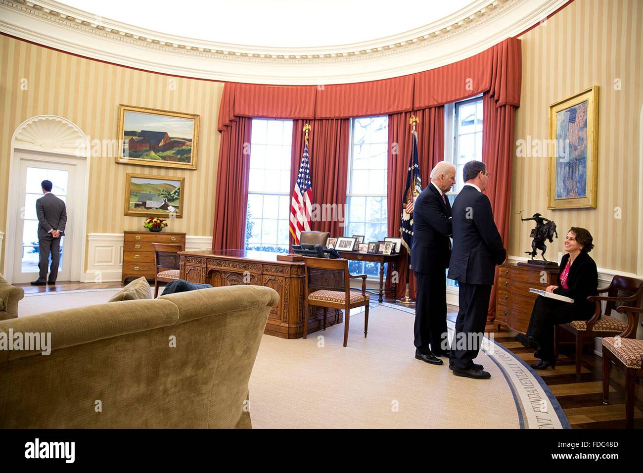 US-Vizepräsident Joe Biden und Verteidigungsminister Ashton Carter sprechen mit Cecilia Mu oz, inländische Politik Rat Direktor im Oval Office des weißen Hauses, als Brian Mosteller, Director of Operations Oval Office, aus dem Fenster 17. Februar 2015 in Washington, DC schaut. Stockfoto