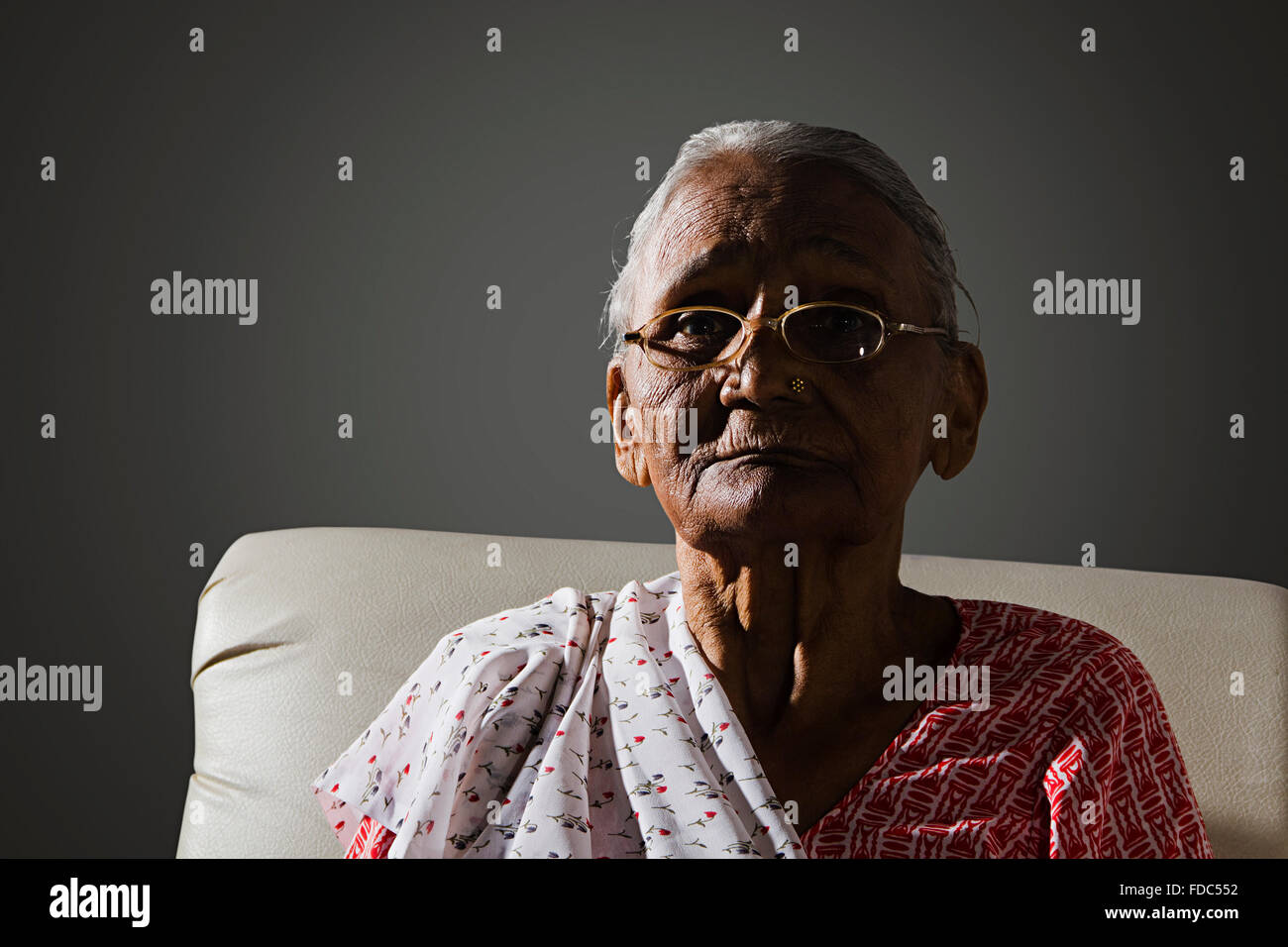 1 ältere Erwachsene Frau sitzen Sofa Angst Denken Stockfoto