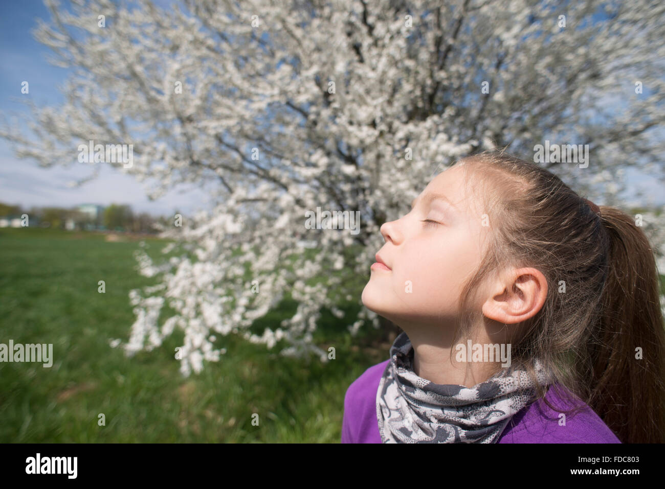 Kind Mädchen genießen Frühlingssonne im Freien mit geschlossenen Augen Stockfoto