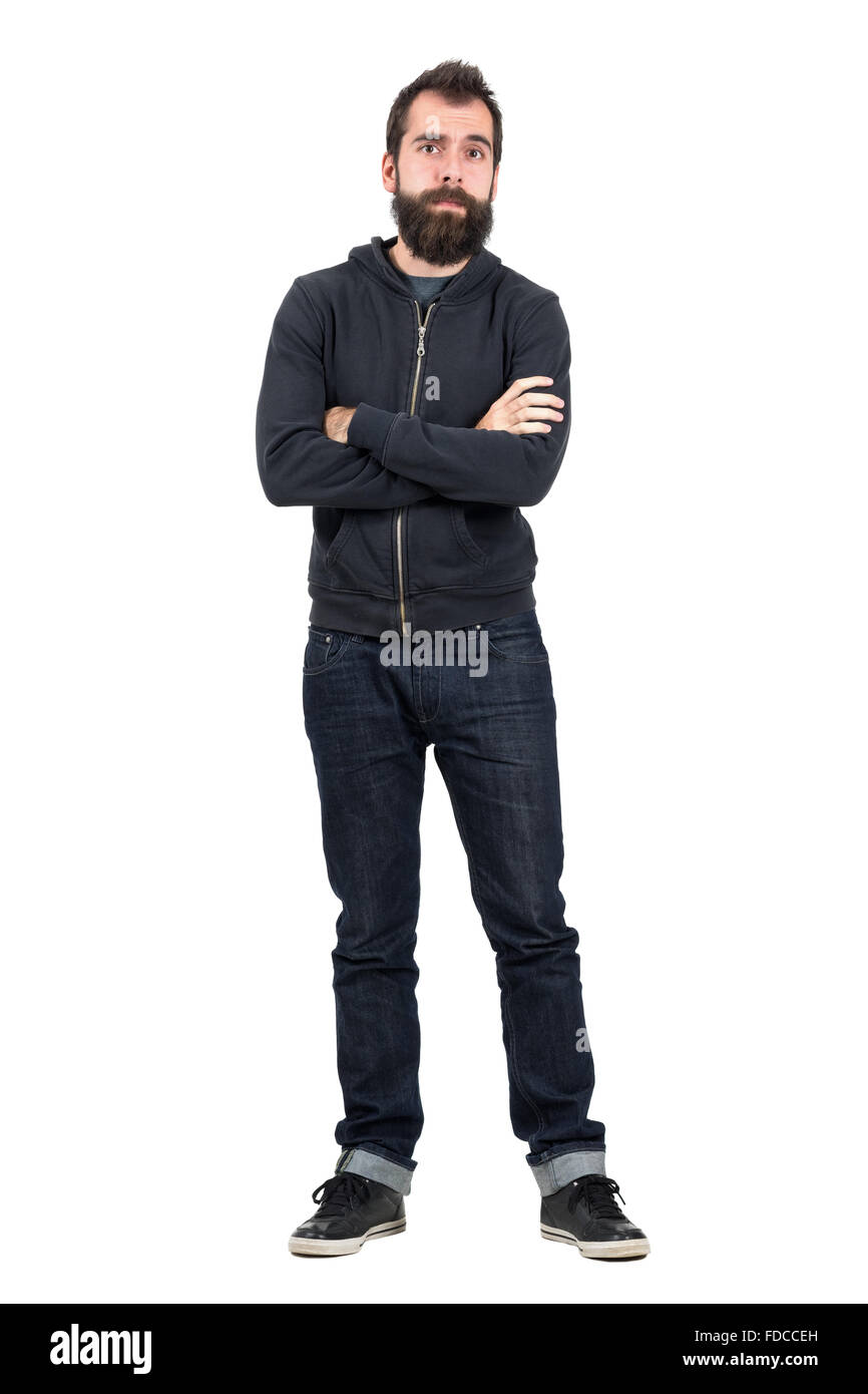 Skeptisch Hipster in schwarzem Sweatshirt mit Kapuze mit verschränkten Armen Blick in die Kamera. Ganzkörper-Länge-Porträt über weißen isoliert Stockfoto