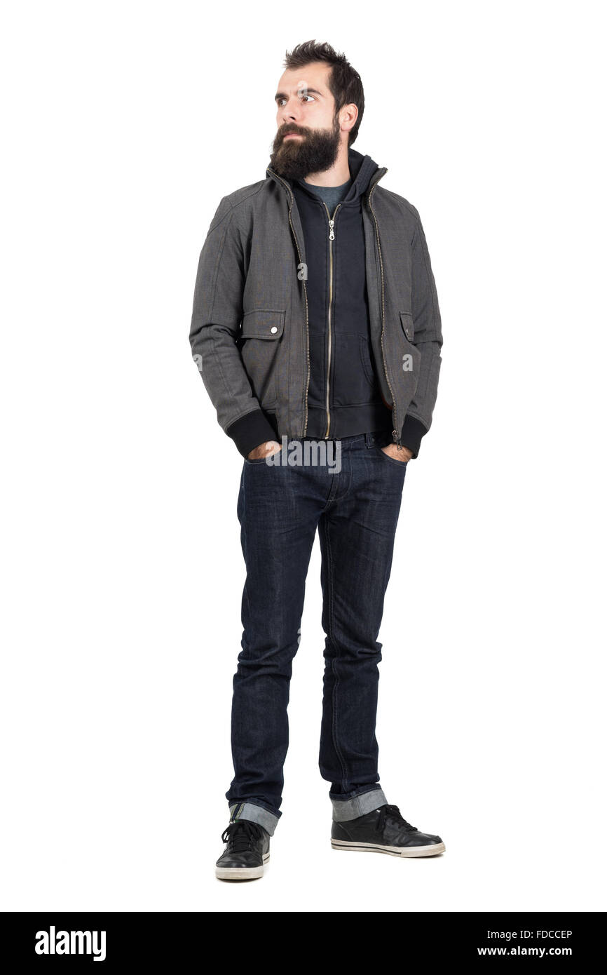 Zuversichtlich Hipster tragen Jacke über Sweatshirt mit Kapuze wegschauen mit Händen in den Taschen. Ganzkörper-Länge-Porträt isoliert Stockfoto