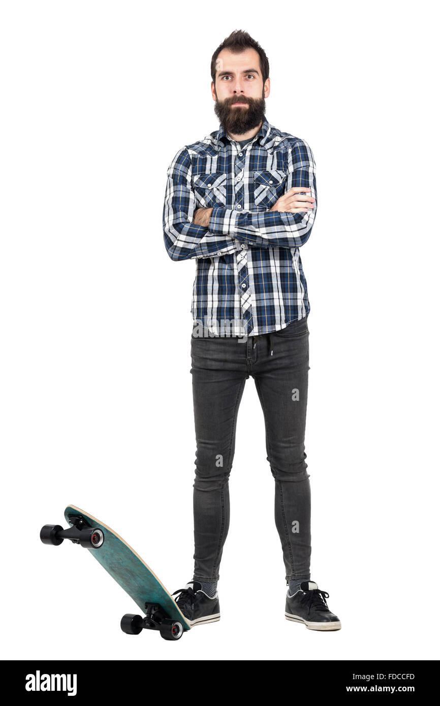 Zuversichtlich bärtige Hipster trägt karierte Tartan Shirt posiert mit seinem Skateboard. Ganzkörper-Länge-Porträt über weißen isoliert Stockfoto