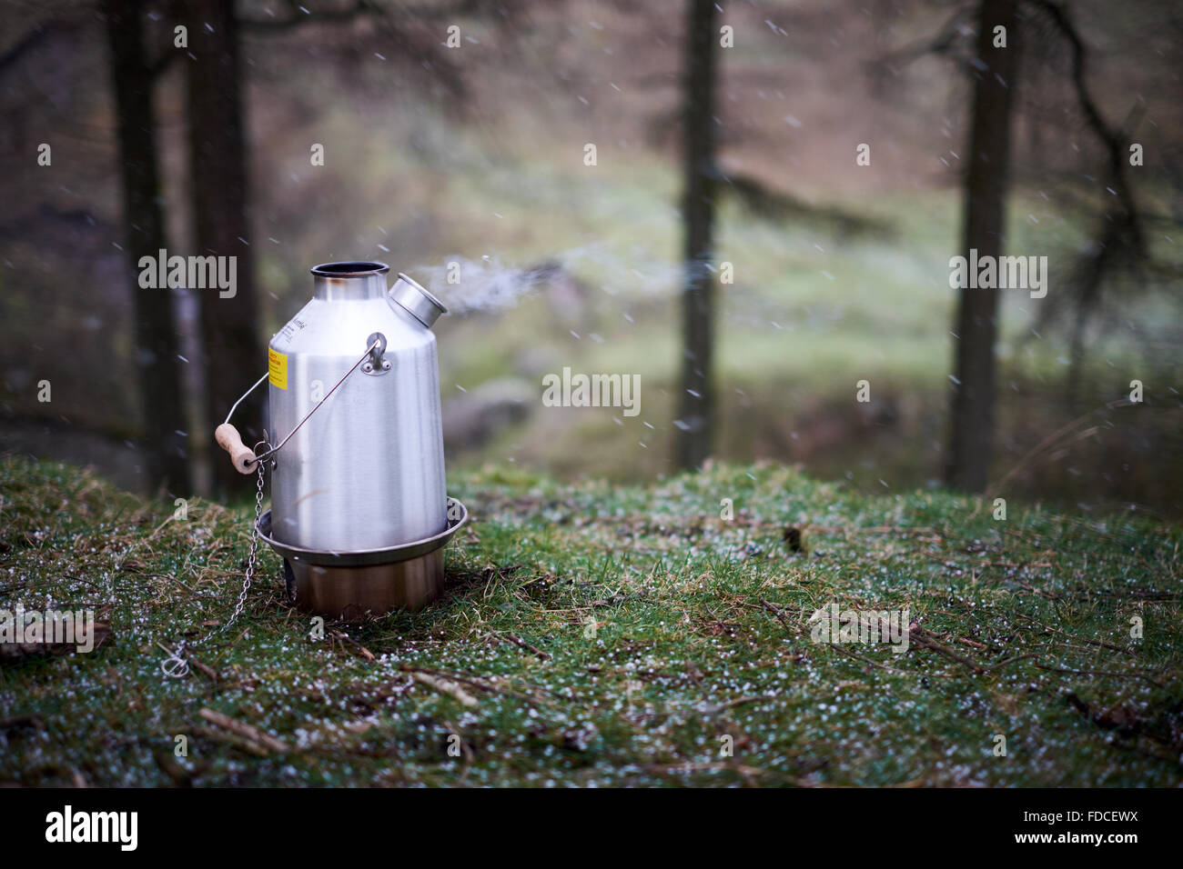 Ein Kelly Kettle angezündet und brennen mit Dampf. Schuss im Schnee / Hagel / winter Stockfoto
