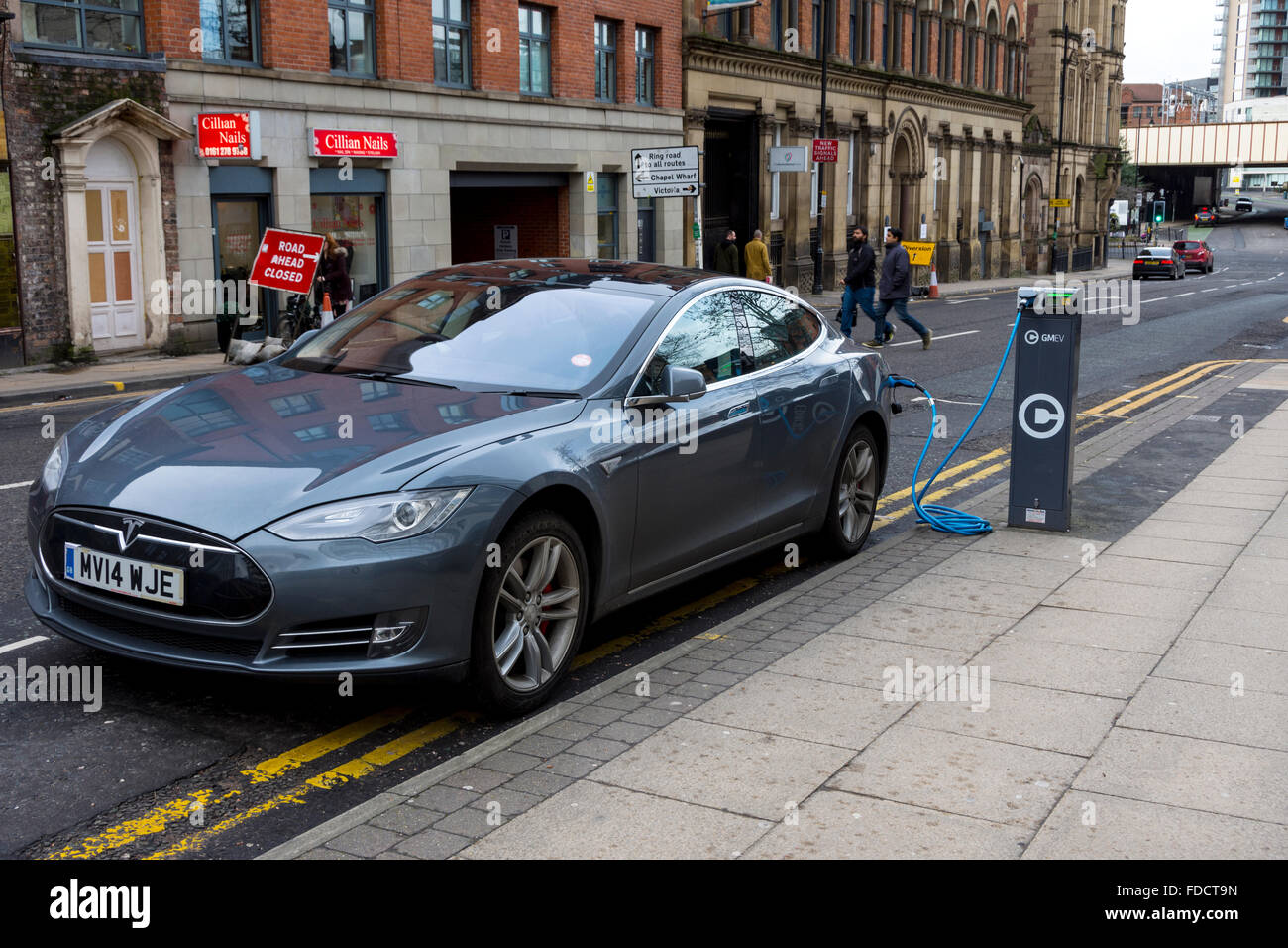Punkt mit einem Auto, einem Tesla Model S, Ladestation für Elektroautos verbunden, Blackfriars Street, Manchester, UK Stockfoto