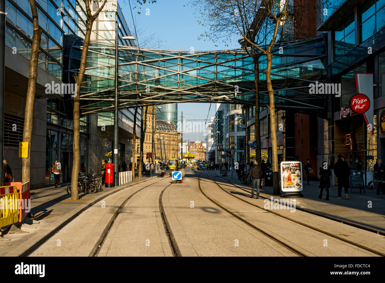 Die Fußgängerbrücke und Straßenbahn verfolgt, Corporation Street, in der Nähe von Exchange Square, Manchester, England, UK Stockfoto