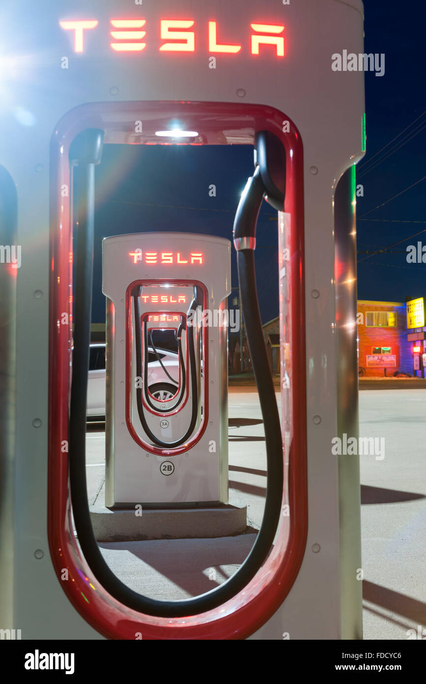 Nacht-Bild der Tesla Batterie aufladen Station Blick durch die Cutaways zu einer Reihe von Plugin-Ladegeräte Stockfoto