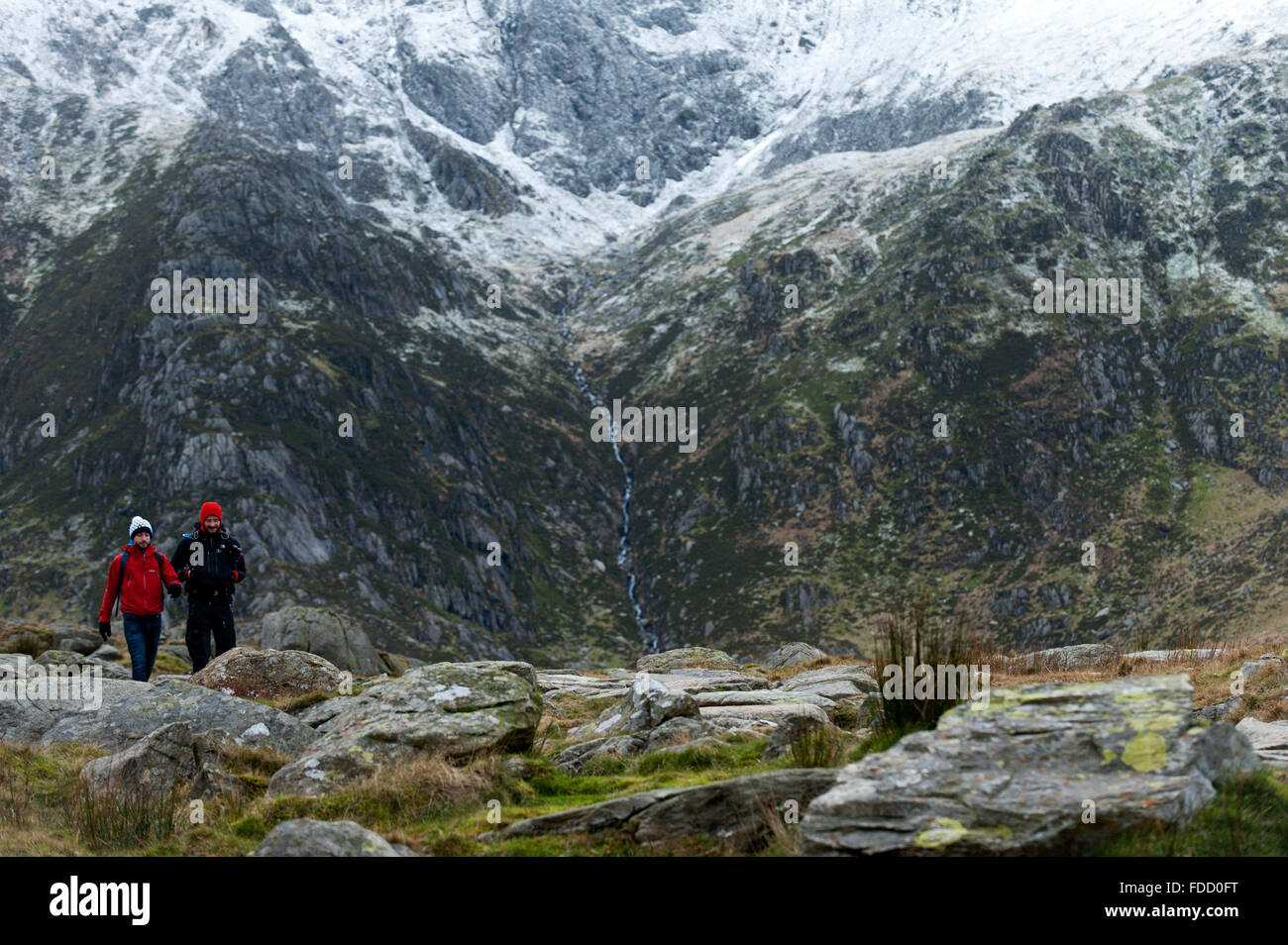 Snowdonia-Nationalpark, Gwynedd, Wales, UK. 30. Januar 2016. Wanderer auf den Pisten in der Nähe von Llyn Ogwen. Nach einem Höhenweg milden Zauber Temperaturen auf um heute Morgen im Snowdonia National Park Null gesunken. Eine Prise Schnee deckt die Gipfel und es gibt einen starken Westwind geben eine viel niedrigere "feels like" Temperatur. Bildnachweis: Graham M. Lawrence/Alamy Live-Nachrichten. Stockfoto