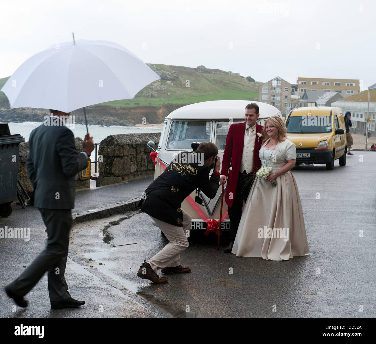 Braut und Bräutigam fotografiert vor einem Vintage-Volkswagen-VW-Bus ca. 1965 Oa einen regnerischen Tag in St. Ives Cornwall UK Europe Stockfoto