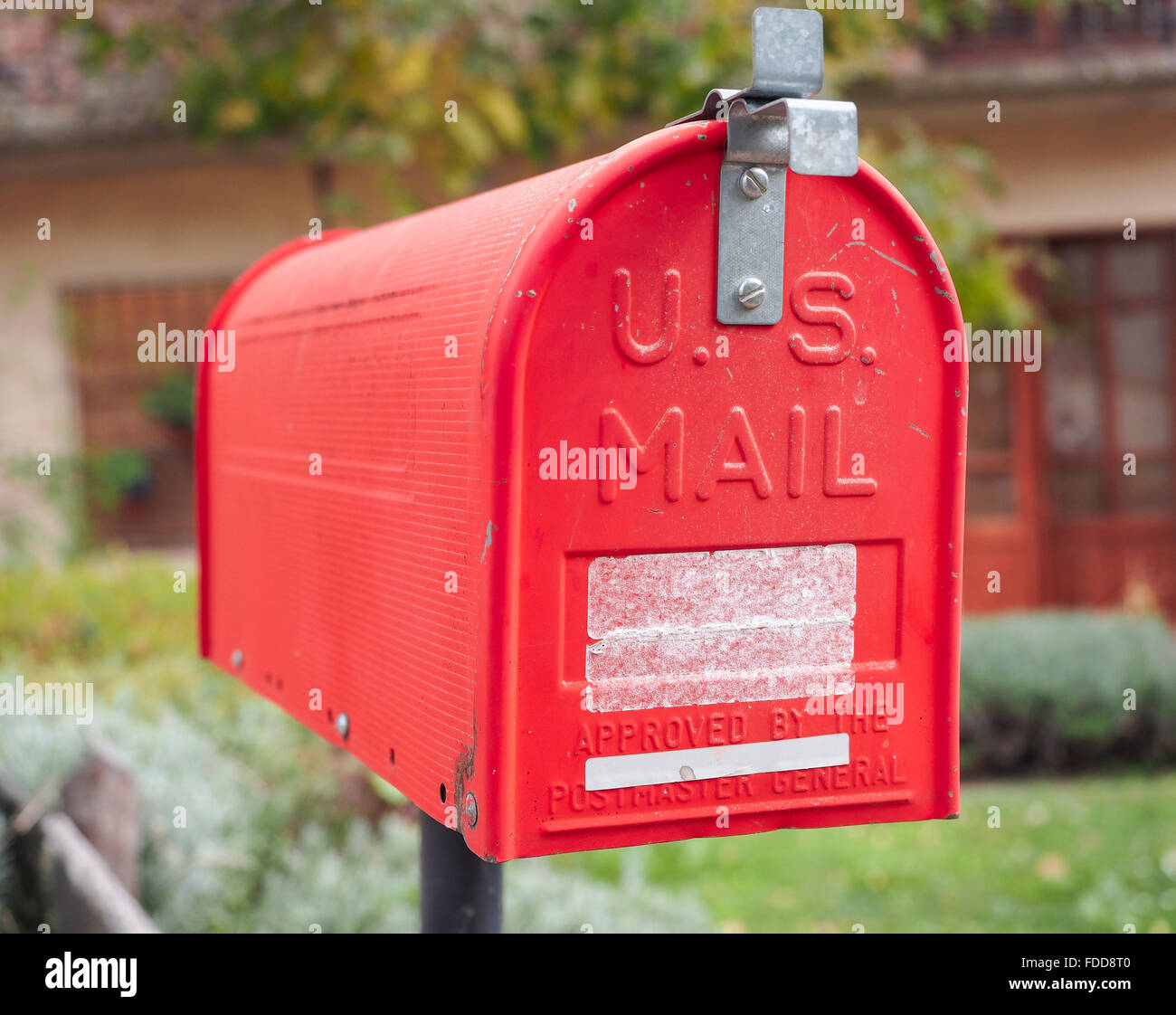 Eine alte home Letter Box, rot lackiert, mit Hintergrund der ländlichen Haus Stockfoto
