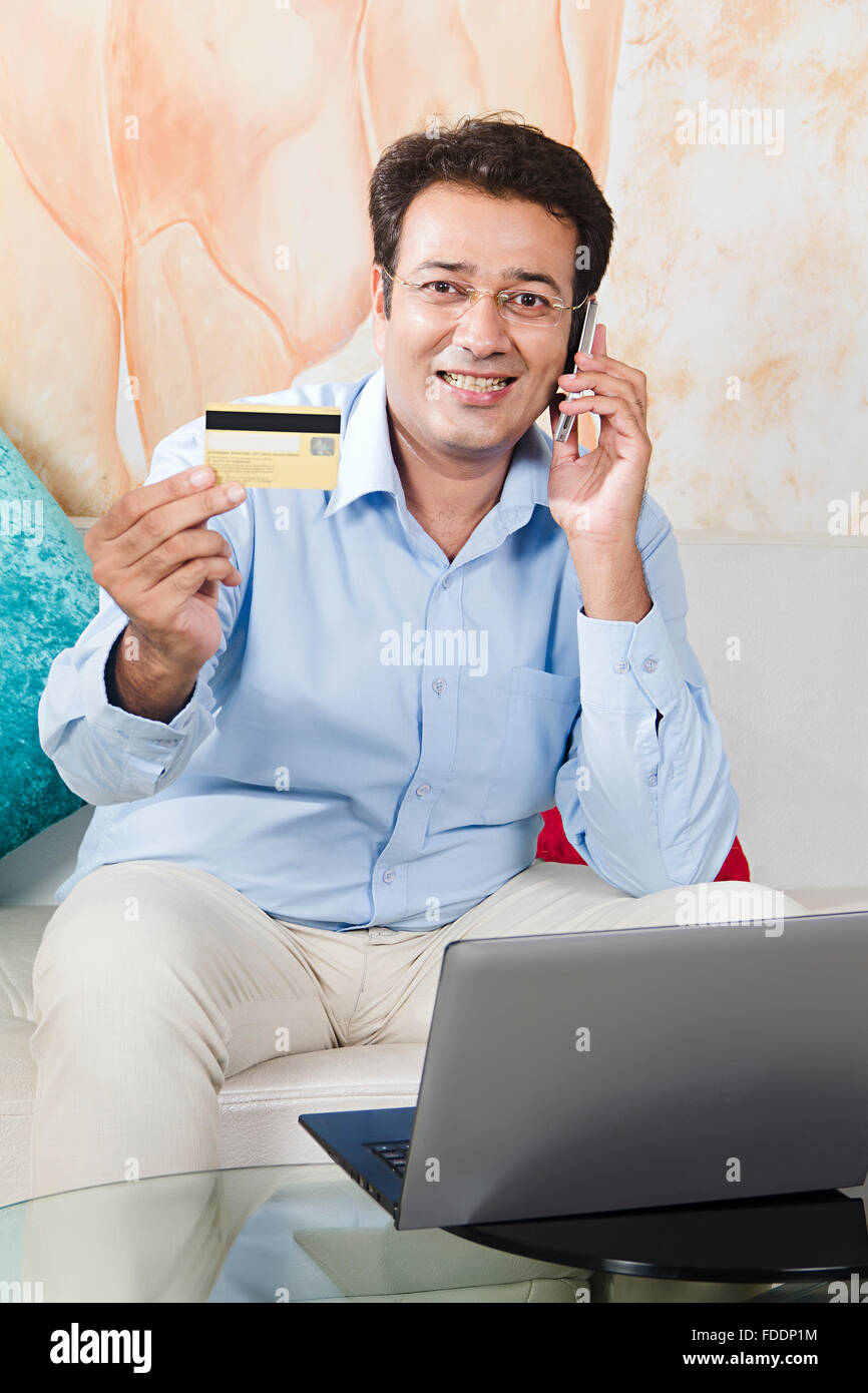 1 Erwachsener Mann Laptop und Kreditkarte Übersicht Online Einkaufen mit Handy sprechen Stockfoto